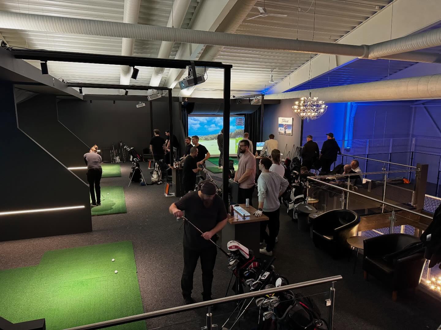 Golfsimulatorer och spelare på hallens övervåning