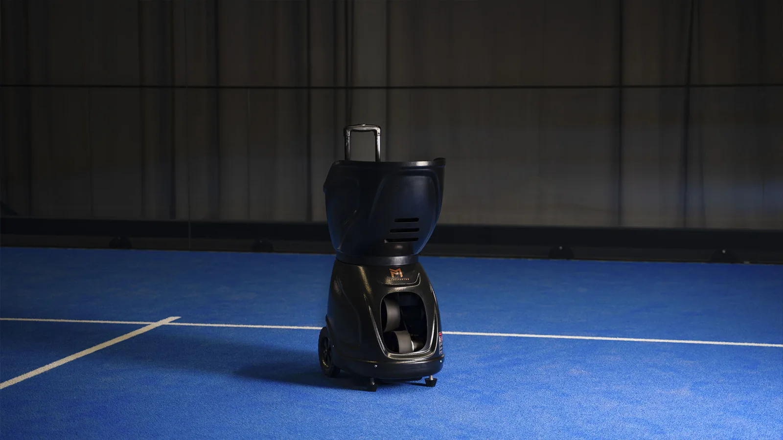 Padelmaster bollmaskin på blå padelbana i Bålsta Padel Clubs hall