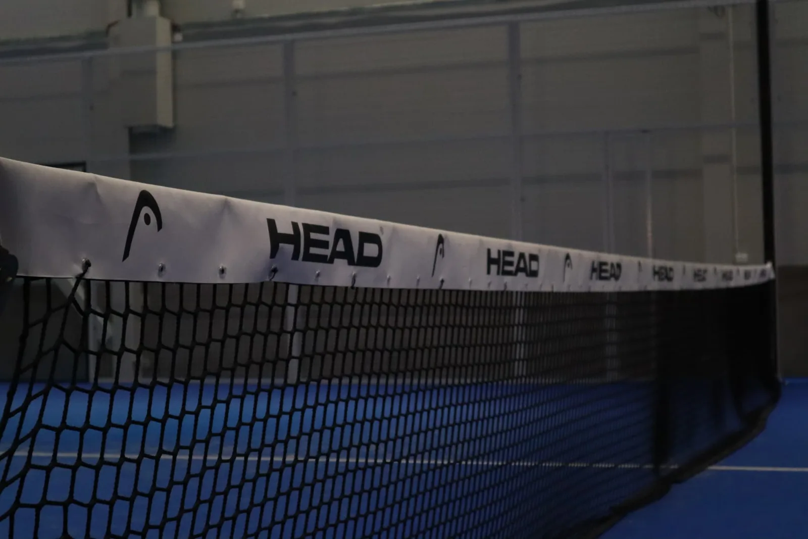 Padelnät i närbild med blå bana i Bålsta Padel Club